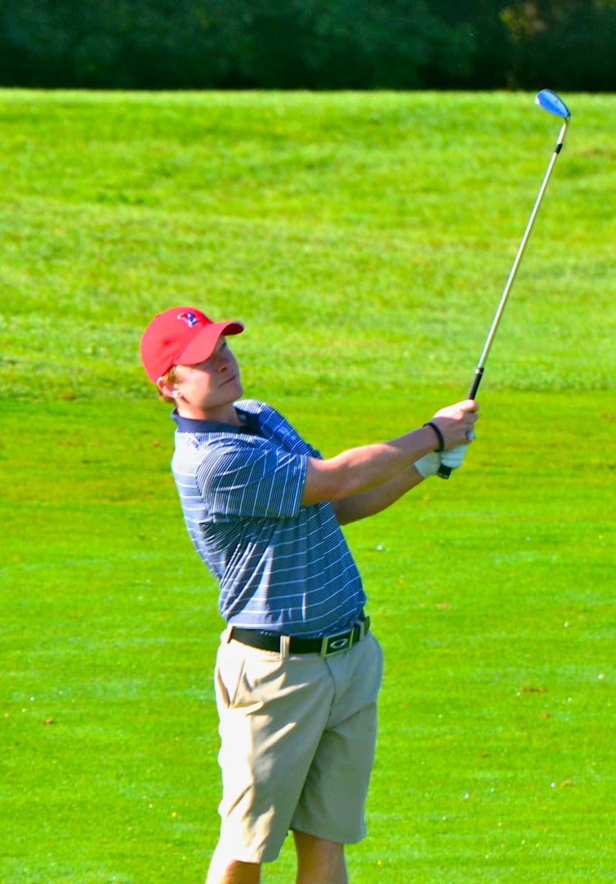 Austin Powell hitting an iron shot during college golf